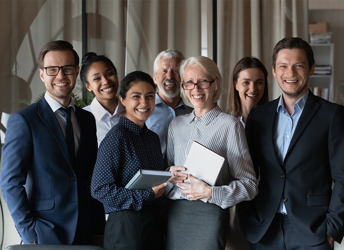 Read Our Reviews - Portrait of a Smiling Group of Diverse Employees Dressed in Business Attire Standing in an Office